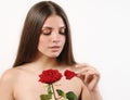 Cute beautiful woman tears off petals of red rose on white background Royalty Free Stock Photo