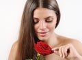 Cute beautiful woman tears off petals of red rose Royalty Free Stock Photo