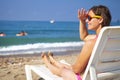 Cute beautiful young woman sunbathing on sunbed on sea beach. Tanned girl on sea. Relax on sea beach Royalty Free Stock Photo