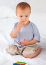 Cute, bed and baby eating biscuit for yummy snack playing with abacus for education. Child development, sweet and hungry