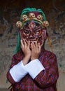 A Bhutanese boy plays with terrific demon mask which for the lama dance . Bumthang, central Bhutan.