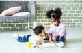 Cute black african american little girl and boy drawing book on floor indoors, African people - Children