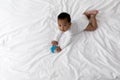 Cute Black Baby Playing With Rattle Toy While Lying On Bed Royalty Free Stock Photo