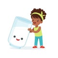 Cute black little girl and funny milk glass with smiling human face playing and having fun, healthy childrens food Royalty Free Stock Photo