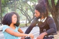 Cute black woman is talking to cyclist outdoors.