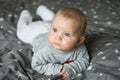Cute blond baby with blue eyes is laying on bed Royalty Free Stock Photo