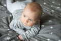 Cute blond baby with blue eyes is laying on bed, view from above Royalty Free Stock Photo