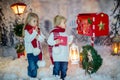 Cute blond children, boy and girl, siblings, posting Christmas letter to Santa Claus, winter day Royalty Free Stock Photo