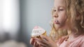 Cute blond girl eating creamy cake, unhealthy snacks, caries and diabetics risk Royalty Free Stock Photo