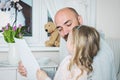 Cute blond girl giving her father a drawing, fathers day