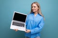 cute blond girl holding laptop with blank space screen on blue background Royalty Free Stock Photo