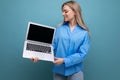 cute blond girl showing laptop with blank space screen on blue background Royalty Free Stock Photo