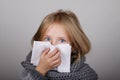 Cute blond hair little girl blowing her nose with paper tissue. Child winter flu allergy health care concept Royalty Free Stock Photo