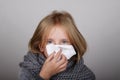 Cute blond hair little girl blowing her nose with paper tissue. Child winter flu allergy health care concept Royalty Free Stock Photo