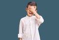 Cute blond kid wearing elegant shirt smiling and laughing with hand on face covering eyes for surprise Royalty Free Stock Photo