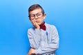 Cute blond kid wearing nerd bow tie and glasses thinking looking tired and bored with depression problems with crossed arms Royalty Free Stock Photo