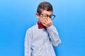 Cute blond kid wearing nerd bow tie and glasses tired rubbing nose and eyes feeling fatigue and headache Royalty Free Stock Photo