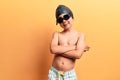 Cute blond kid wearing swimwear and swimmer glasses happy face smiling with crossed arms looking at the camera Royalty Free Stock Photo