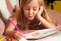 Cute blond little girl drawing on the paper