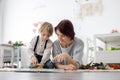 Cute blond preschool child, blond boy with pet maltese dog, reading book at home with mother Royalty Free Stock Photo