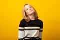Cute blond teen girl. Studio image of smiling young girl on yellow background