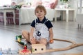 Cute blond toddler child, boy, playing with colorful trains and railroad at home Royalty Free Stock Photo