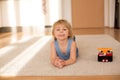 Cute blond toddler child, playing with big toy car Royalty Free Stock Photo