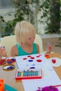 Cute blond toddler girl drawing with stamps, paints and color pencils Royalty Free Stock Photo