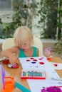 Cute blond toddler girl drawing with stamps, paints and color pencils Royalty Free Stock Photo