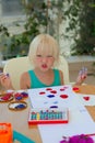 Cute blond toddler girl drawing with stamps, paints and color pencils Royalty Free Stock Photo