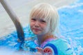 Cute blond toddler girl wearing armbands in the pool Royalty Free Stock Photo