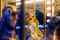 Cute blonde boy enjoying Christmas fair. Little child riding on a vintage carousel merry go round. Outdoors entertainment Royalty Free Stock Photo