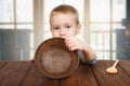 Cute blonde boy shows empty plate Royalty Free Stock Photo