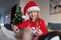 Cute blonde caucasian girl 7 years old playing with her baby sister near Christmas tree. Xmas celebrate, happy new year Royalty Free Stock Photo