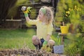 Cute blonde child girl having fun playing little gardener