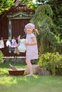 Cute blonde child girl plays toy wash in summer garden Royalty Free Stock Photo