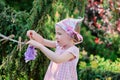 Cute blonde child girl plays toy wash in summer garden Royalty Free Stock Photo