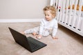Cute blonde curly toddler baby boy working on laptop. Little kid child using technology. Early age education and development. Royalty Free Stock Photo