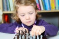 Cute, blonde girl playing chess Royalty Free Stock Photo