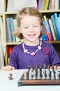 Cute, blonde girl playing chess Royalty Free Stock Photo