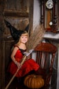 cute blonde halloween witch girl with broom