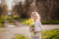 cute blonde happy little girl with yellow daffodils in the spring country Royalty Free Stock Photo