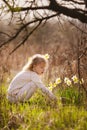 cute blonde happy little girl with yellow daffodils in the spring country Royalty Free Stock Photo