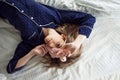 Cute blonde in her bed in blue pajamas and sleep mask, top view Royalty Free Stock Photo