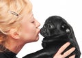 Cute blonde kissing a black pug puppy Royalty Free Stock Photo