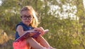 A cute blonde little girl with big glasses reading a book Royalty Free Stock Photo