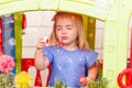 A cute blonde little girl with a funny face, blowing soap bubbles Royalty Free Stock Photo