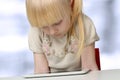 Cute blonde little girl with digital tablet