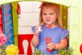 A cute blonde little girl with a funny face, blowing soap bubbles Royalty Free Stock Photo