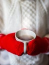 Cute blonde little girl holding hot steaming tea cup close up photo Royalty Free Stock Photo